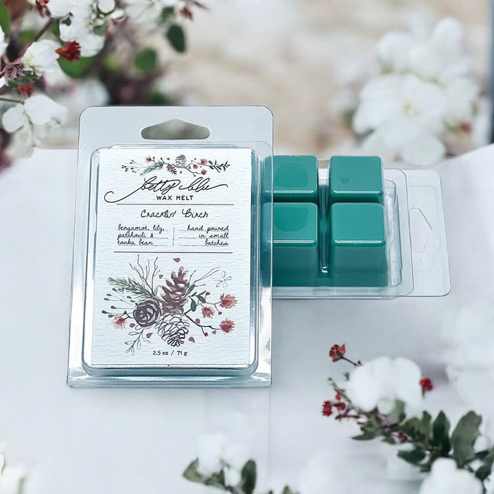 Wax melt packaging with illustrated pine cones and winter florals.