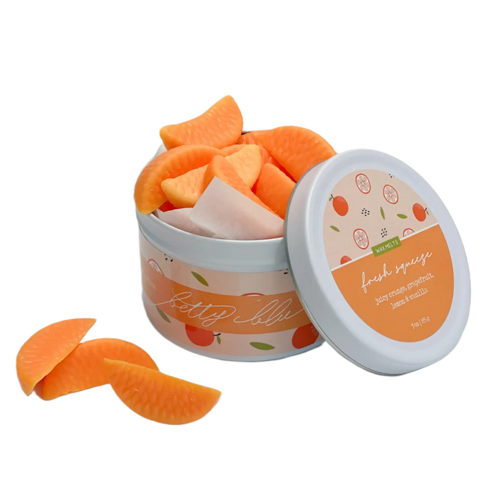 Orange slice-shaped citrus wax melts in a white tin, hand-poured in small batches