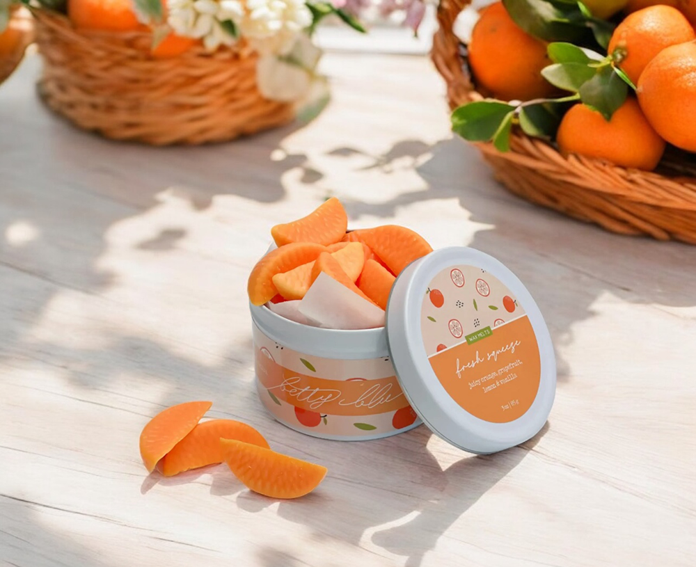 Orange slice-shaped citrus wax melts in a white tin, hand-poured in small batches