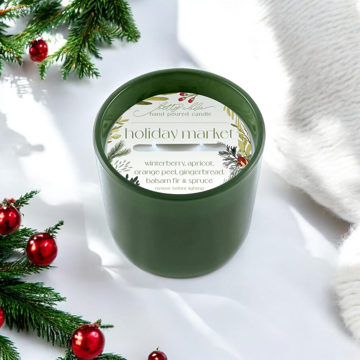 Holiday Market candle on white background with festive branches and ornaments