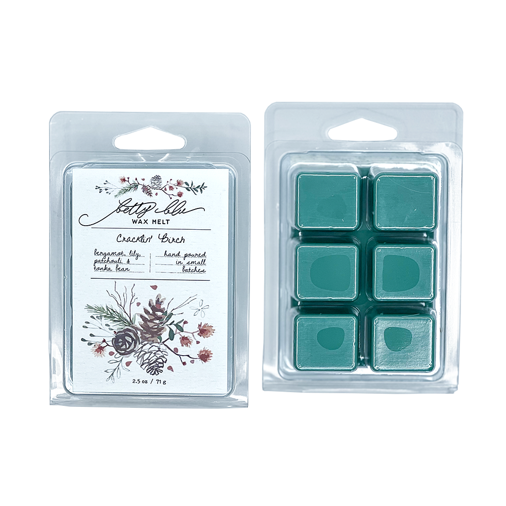 Wax melt packaging with illustrated pine cones and winter florals.